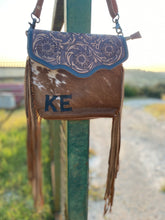 Load image into Gallery viewer, custom branded cowhide crossbody purse with tooled leather flap and brown leather fringe 
